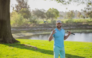 Mutlu gülümseyen golfçünün portresi golf sopasıyla golf sahasına giriyor.