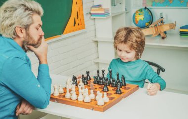 Babalar Günü. Satranç stratejisi geliştiren konsantre bir çocuk. Satranç oynarken akıllı konsantre ve düşünceli çocuk.