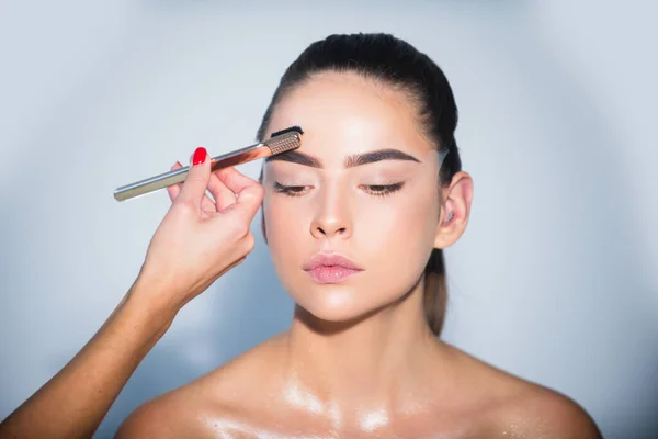 Beauty makeup. Girl with beautiful bright make up. Woman applying black mascara on eyelashes with makeup brush. Brows coloring, wax and lamination. Fashion and beauty, cosmetics, beauty salon