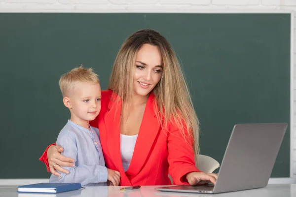 Mother and son together using computer laptop. School child learning education online lesson. Teacher explains lesson to school child. Elementary school kids learning. Mother and son learning