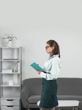 Düşünen öğrenci ya da genç öğretmen. İşyerindeki genç iş kadını. Ofisteki. Resmi sekreter kadın modern ofiste proje üzerinde çalışıyor.