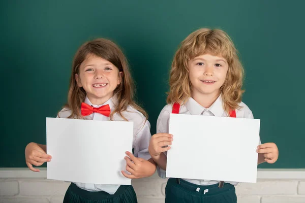 Deux Écoliers Tenant Papier Blanc Vierge Affiche Avec Espace Copie — Photo