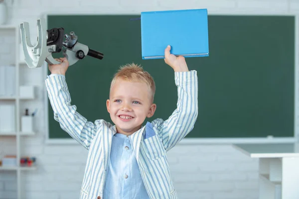 Małe Dziecko Uczące Się Podstawówce Podekscytowany Uczeń Mikroskopem Książką — Zdjęcie stockowe