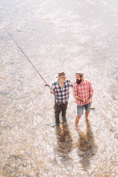 穿着西服的老渔夫和带胡子的休闲男子用钓竿钓鱼 — 图库照片
