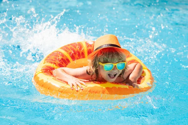 Child in swimming pool with inflatable toy ring. Children summer vacation. Swim for child on float. Beach sea and water fun