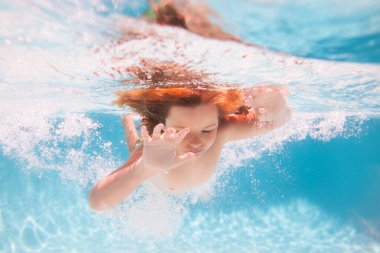 Çocuklar tatil ve yaz tatili konsepti. Çocuk su altında havuzda yüzüyor. Çocuk denizde yüzüyor.