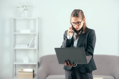 Genç Ciddi İş Kadınları İnternet 'te çalışıyor. Dizüstü bilgisayardan eğitim kursunda internet üzerinden podcast izliyor. İnternetten konferans çağrısı yapıyor. İş kadını telefona cevap veriyor