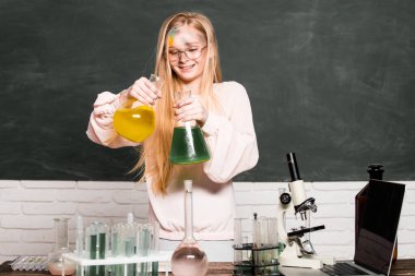 Laboratuvarda deney yapan komik küçük okul çocuğu. Bilim ve eğitim. Laboratuvardaki küçük bilim kadını. Kimyasal deney