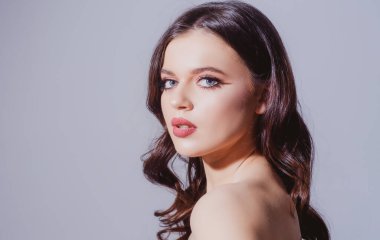 Stüdyoda güzel bir kadın portresi var. Temiz tenli, doğal makyajlı güzel bir kız.