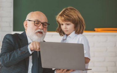 Öğrenci ve kıdemli öğretmen sınıfta. Eğitim konsepti. Okul öğrenme konsepti. Erkek ilkokulu