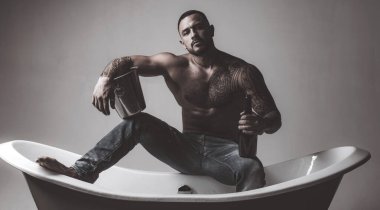 Stresli bir iş gününden sonra rahatlamanın en iyi yolu. Atheltic İspanyol adam dinlenmek için şampanya içiyor. Fit gövde dövme ile Güçlü latino adam dinlenmek ve banyo keyfini çıkarın. Stres giderici spa dinlenmek.