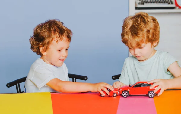 Children playing with toy car at kindergarten. Child from elementary school. Caucasian kids boys plays with colorful toy cars