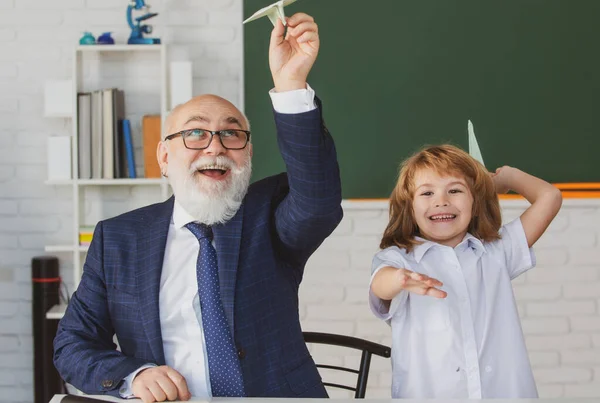 School break with teacher. Pupil with airplanes. Education, teachering, learning. Schoolboy in classroom