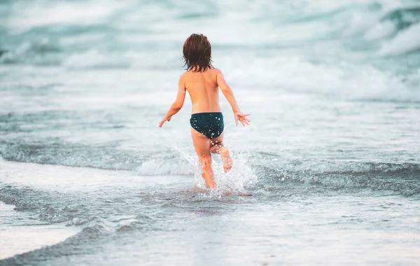 子供との休暇 海を走っている幸せな子供 子供の男の子はビーチで楽しんでいます 夏の子供たち — ストック写真