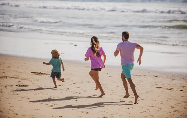 ビーチでジョギングをしている父 健康的な家庭生活をコンセプトとする 夏休みの海で — ストック写真