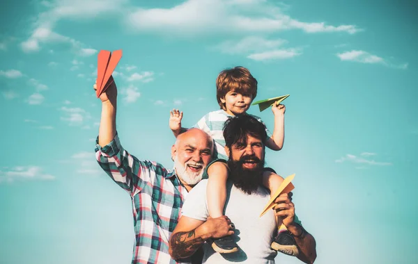 Fathers day - grandfather, father and son are hugging and having fun together