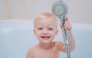 Şirin Bebek Banyoda saç yıkıyor. Sağlık ve günlük rutin için kavram. Bebek duş aldıktan sonra bir havlu ile. Çocuk banyo