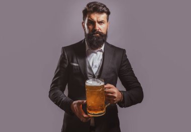 Sakallı ve bıyıklı hippi bira içer. Almanya Bavyera. Bira zamanı. Yakışıklı barmen elinde yarım litre bira tutuyor.
