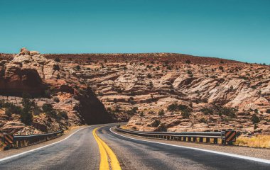 Long Desert Highway California 'da. Yüksek kayalıklara karşı yol. Tepe köy yolu