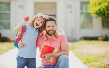 Okul bahçesinde mutlu bir aile. Okullu çocuk babamla aynı okula gidiyor.