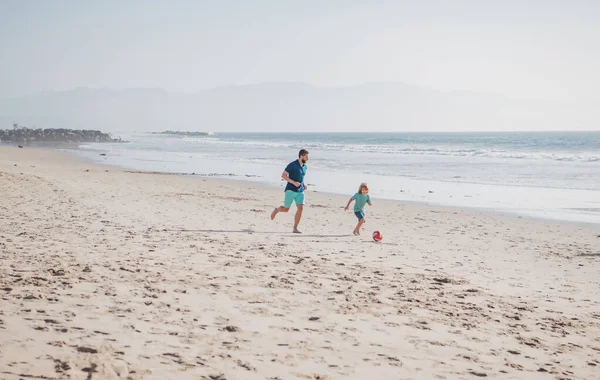 父と息子は夏休みにビーチでサッカーやサッカーをします 屋外で楽しむお父さんと子供 週末の男の家族の概念 — ストック写真
