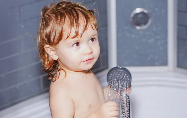 Todler en la ducha bebé divertido en la ducha bebé sonriente se baña en un  baño con espuma y pompas de jabón