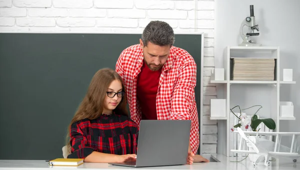 教師は学校の子供にレッスンを説明する コンピュータのノートパソコンで学ぶ小学生 — ストック写真