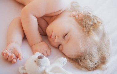 Bebek evde oyuncakla uyuyor, çocuk yatakta uyuyor. Bebek oyuncaklarla uyuyor. Çocukların uykusu geldi. Sevimli küçük çocuklar uyuyorlar. Güzel, sağlıklı, huzurlu bir uyku çekiyorlar.