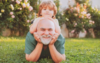 Yaşlı baba oğluyla oynuyor, mutlu babalar günü, mutlu çocuk ve dışarıda oynayan baba. Baba oğlunu parka geri götürüyor. Sağlık sigortası aile yaşam tarzı. Baba ve oğul.