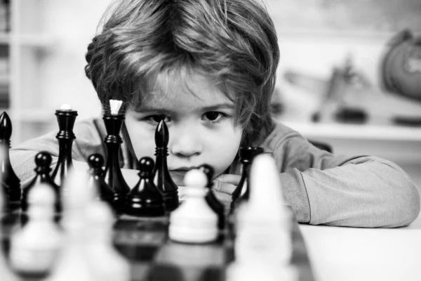 Little boy playing chess. Kids educational games, child early development. Boy think or plan about chess game, vintage style for education concept