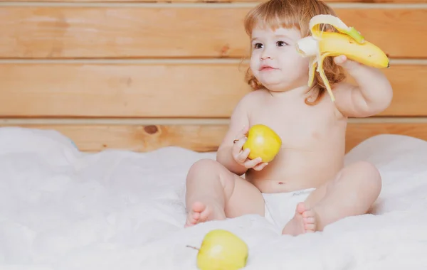 幸せかわいい赤ちゃんはリンゴとバナナを食べる — ストック写真