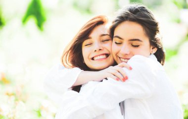 Parktaki güzel kızlar. İki güzel kızıl kız. Neşeli kardeş, kavramı kucakla.