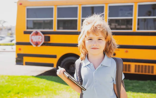 Back to school. Happy child near school bus. Cute school boy potrait
