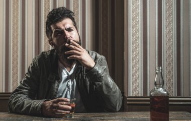 Adam brendi ya da viski içer. Sakallı adam takım elbise giyip viski ya da konyak içiyor. Sommelier alkollü içeceğin tadını alıyor. İçki ve parti konsepti. Degukasyon ve tatma