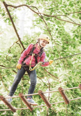 Yüksek halatlar yürür. Kask - Çocuk oynamak için güvenlik ekipmanları. Küçük çocuk kask ve güvenlik ekipmanları ile macera aktivite parkı tırmanma. Kaygısız çocukluk