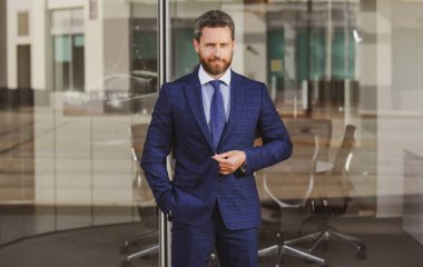 Yakışıklı bir ofis çalışanı. İş merkezinin yakınında kahve molası. İş adamı iş merkezinin yakınındaki caddede duruyor.