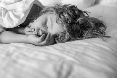 Yatakta çocuklar, beyaz yatak odasında mutlu uyku zamanı. Çocuk yatakta uyuyor.