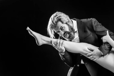 Kadın bacaklı, takım elbiseli yakışıklı bir adam. Ayak fetişisti. Lüks ve ataerkil düzen. Bacağını yala.