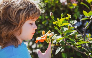 Doğa parkında bahar çocuğu. Açık havada çiçekli bir çocuk. Çiçek bahçesi