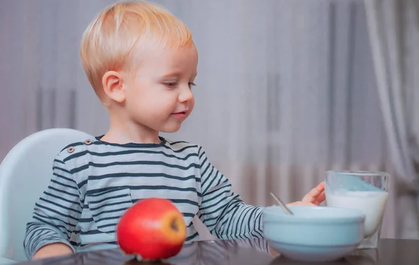 Baby nutrition. Eat healthy. Toddler having snack. Drink milk. Child hold glass of milk. Kid cute boy sit at table with plate and food. Healthy food. Healthy nutrition. Boy cute baby eating breakfast.