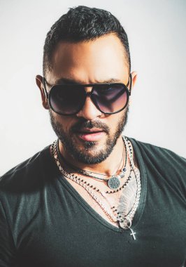 Güneş gözlüklü yakışıklı bir adam. Erkek yüzü. Yakışıklı, erkeksi bir adamın portresi. Gri duvara karşı memnun iş adamının portresi. Güneş gözlüğü. Şehir modası