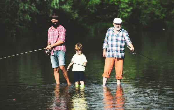 Grandfather, father and grandson fishing together. Coming together. Fly fishing. Father teaching his son fishing against view of river and landscape