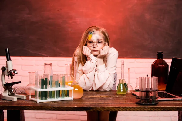 Funny sad schoolgirl scientist in the laboratory. Chemical experiment. Funny schoolgirl kid doing experiments in the chemistry laboratory. Explosion in the lab. Science and education