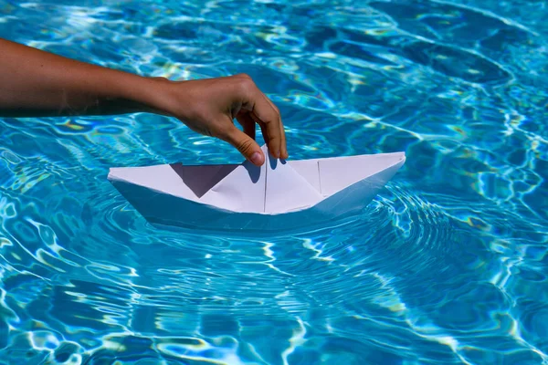 Paper ship in hand ready to sail. Hand holding paper boat on the sea background. Tourism, travel dreams vacation holiday, dreaming traveling, sailing adventure