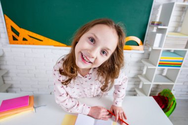 Sınıfta gözlüklü komik bir öğrenci. Tahtada eğlenceli bir çocuk