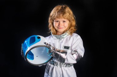 Çocuk astronot uzay kostümü giymiş, siyah giyinmiş.