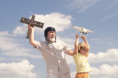 Çocuk çocuk ve büyükbaba uçak ve dört kişilik helikopteri gökyüzüne karşı tutuyorlar. Uçak hayali kuran çocuk pilot pilot.