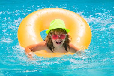 Çocuk havuzda dinleniyor. Çocuk su havuzunda yüzüyor. Yaz çocuk aktiviteleri, su sporları