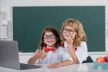 Okul arkadaşları. Okul üniformalı arkadaş canlısı sınıf arkadaşları dersteler. Okuldaki kız ve erkek öğrenciler. Okul çocukları ve arkadaşlık, arkadaşlar. Sınıf arkadaşları, genç ilkokul öğrencileri.