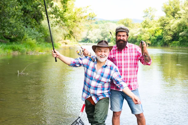 两个男人朋友是在河里钓鱼的渔夫 老父子俩在河边钓鱼 文娱活动 — 图库照片